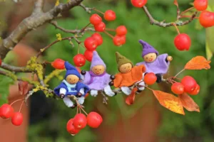 Figurines posées sur une branche de baies rouges